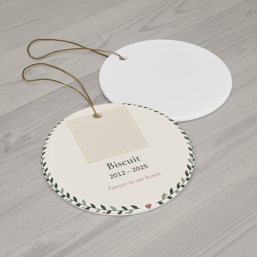 Round ceramic personalized pet memorial ornament with a pet photo, name and dates in a leafy wreath, 'Forever in our hearts' - view 2